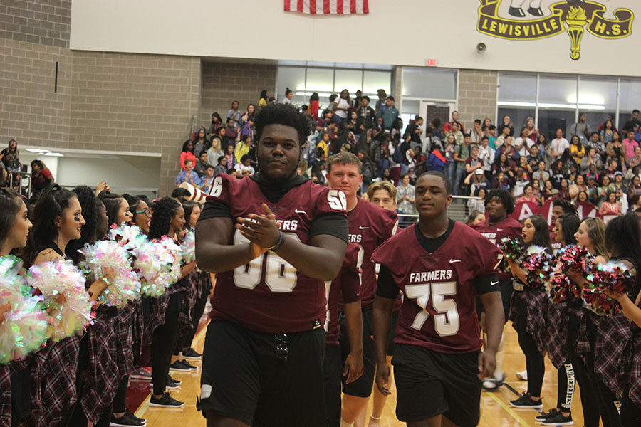 Seniors Jarvis Green (56) and Jeromeiah Thomas (75) lead the football team out at the end of the pep rally.
