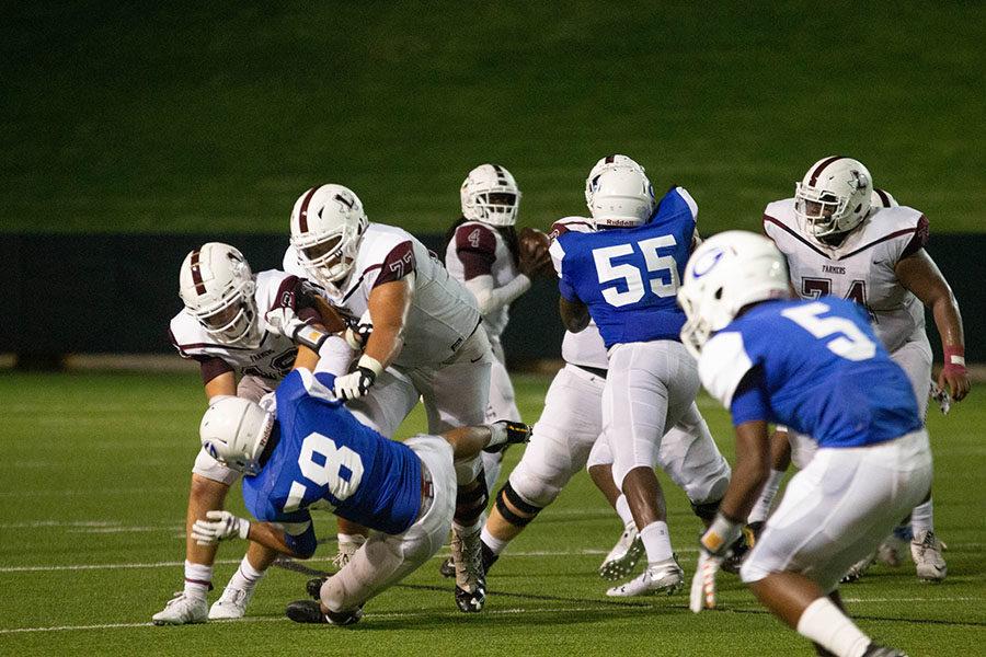 Juniors Spencer Nielsen (72) and Ben McAfee (15) tackle a player.