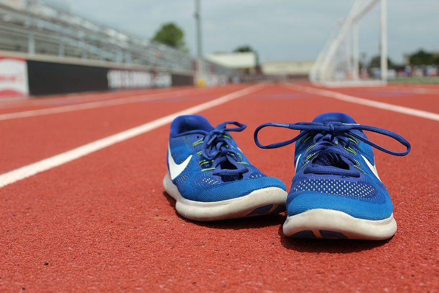 A pair of running shoes sits on the track.