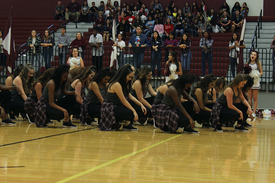 The Farmerettes crouch in position to start their dance.