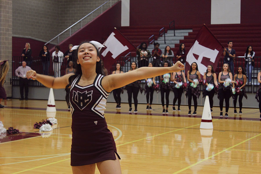 Junior Trish Truong cheers with arms wide open.