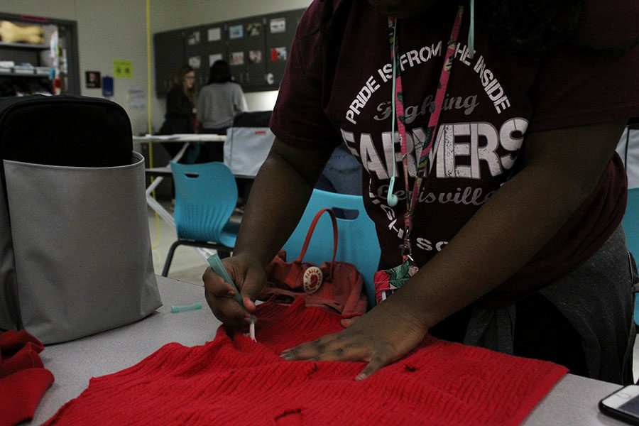 On Thursday, Nov. 29 during fashion club, junior Aliyah Rose distresses a sweater in preparation for the fashion show on Friday, Dec. 7.
