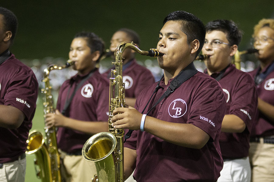 Senior Isaac Ramirez performs a song during halftime along with the rest of the saxophone section at the away game in the Grand Prairie stadium on Friday, Aug. 31.