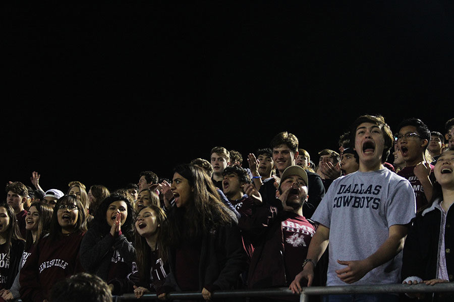 The rowdy crowd cheers as the football team scores a touchdown.