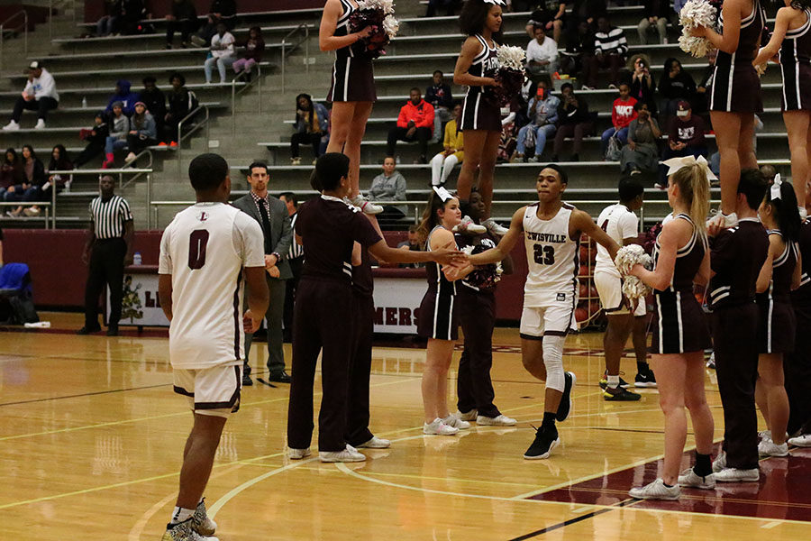 Sophomore guard Kylin Green (23) is welcomed by the cheer squad and fellow teammate senior guard Braon Williams (0). 