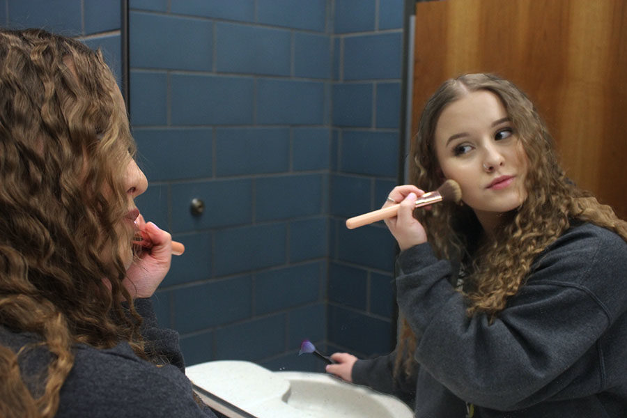 Senior Madyson Fletcher applies her highlighter with a makeup brush.