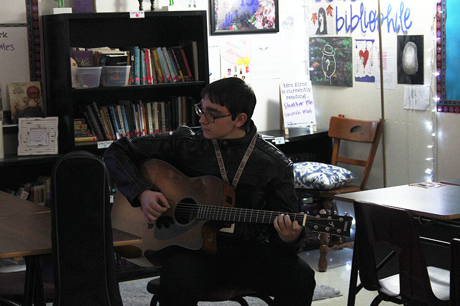 Guitar club president senior Dalton Baham practices with his guitar during the club meeting on Wednesday, Jan. 30.