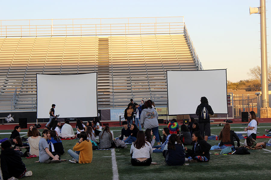 Students from all five high schools try to find open spots to sit before the movie starts on Wednesday, March 20.