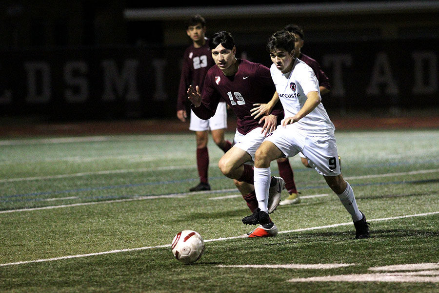 Senior Jesus Luna (19) tries to reach the ball but is pushed back by a Marcus player.