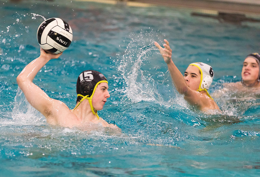 Junior Elliott Busby attempts to shoot a ball through the hoop during a water polo match. Courtesy of Elliott Busby.