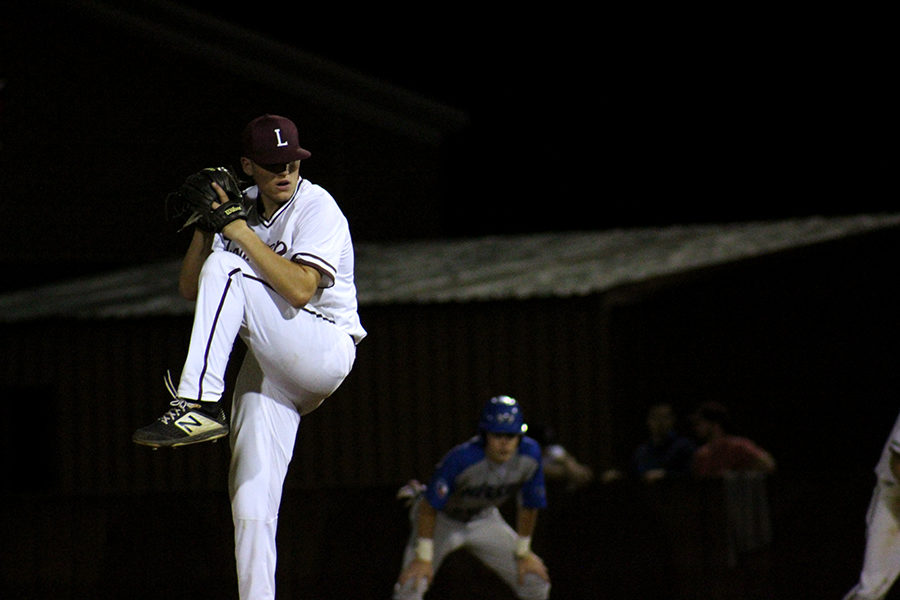 Senior Tony Rochette (7) winds up to pitch the ball at a Hebron player.