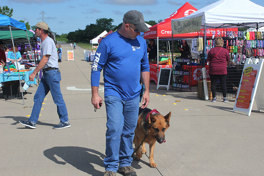Off Leash vendor Justin Ray walks his rescue dog Joe to demonstrate positive behavior to the public at the annual Paws in the Park event on Saturday, May 4.