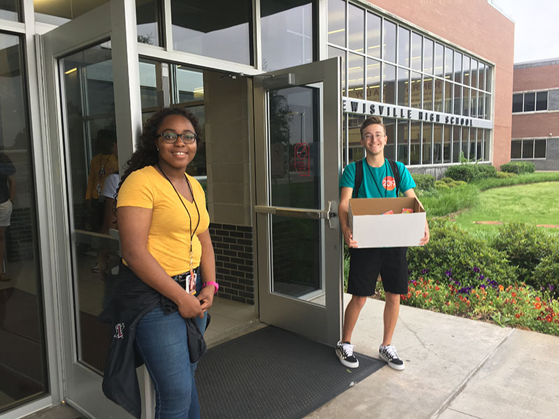 Junior Semi Ojernide and senior Wesley Brewer hold the front door open at Main before school on Monday, May 20.