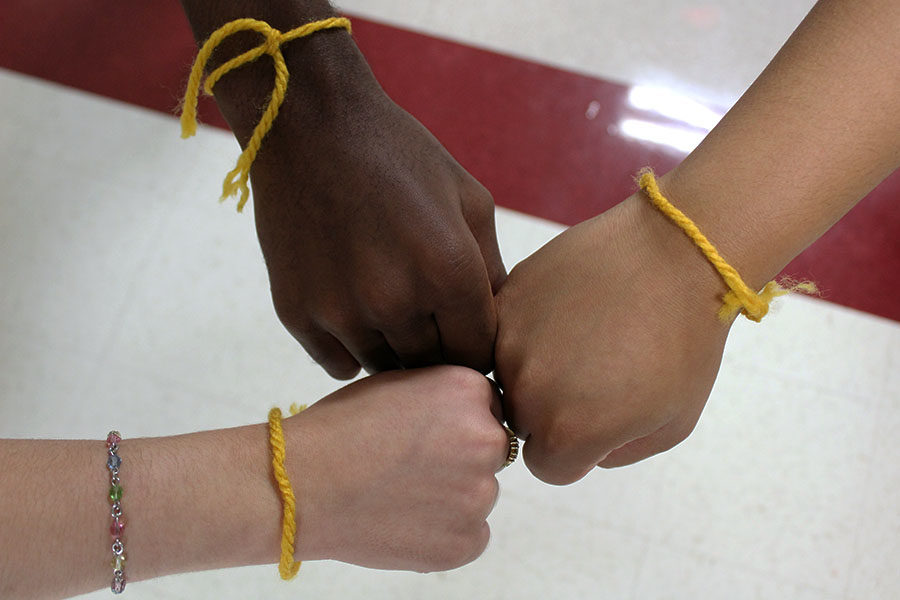 StuCo+gave+out+gold+bracelets+to+students+to+show+support+for+those+suffering+from+childhood+cancer.