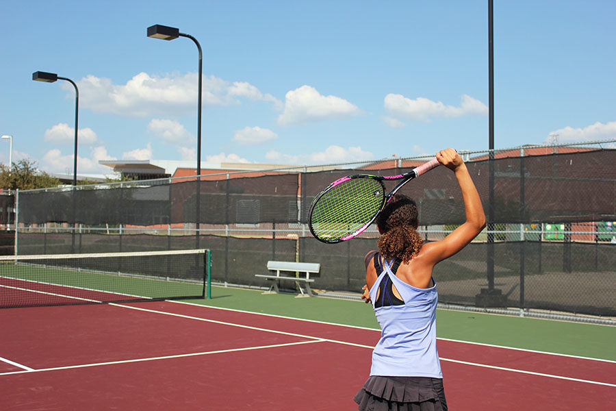 Sophomore+Amber+Rhodes+serves+a+tennis+ball+during+practice+after+school+on+Monday%2C+Sept.+17+with+the+varsity+team.