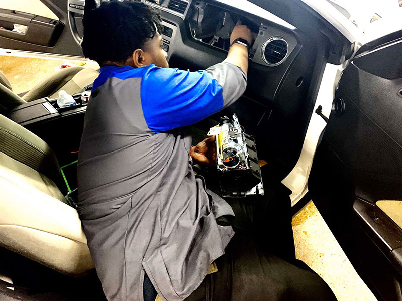 Senior Avante Bond fixes an airbag at Sam Pack’s Five Star Ford Lewisville on Thursday, Feb. 13.