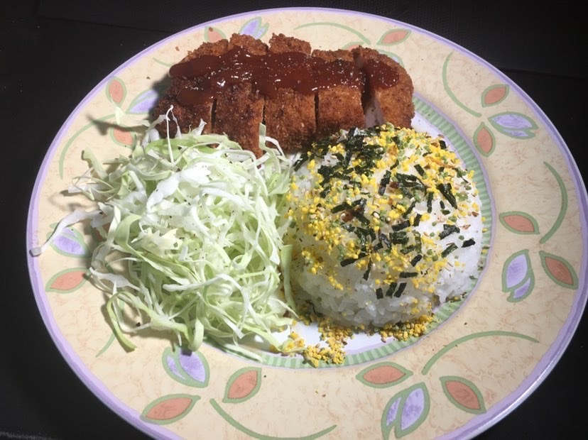 A pork tonkatsu is cooked and prepared by senior Erick Nguyen.