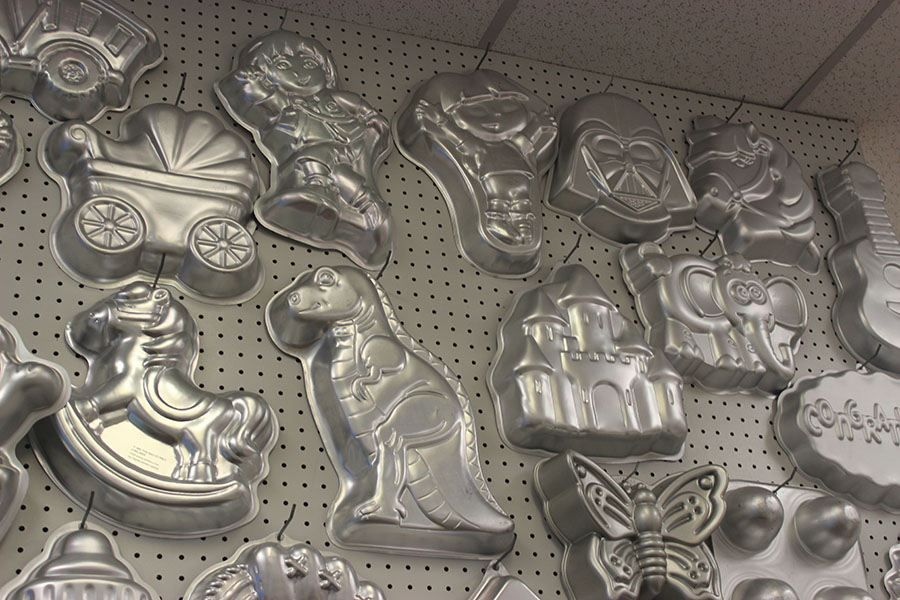 The back wall of the store contains cake molds. 