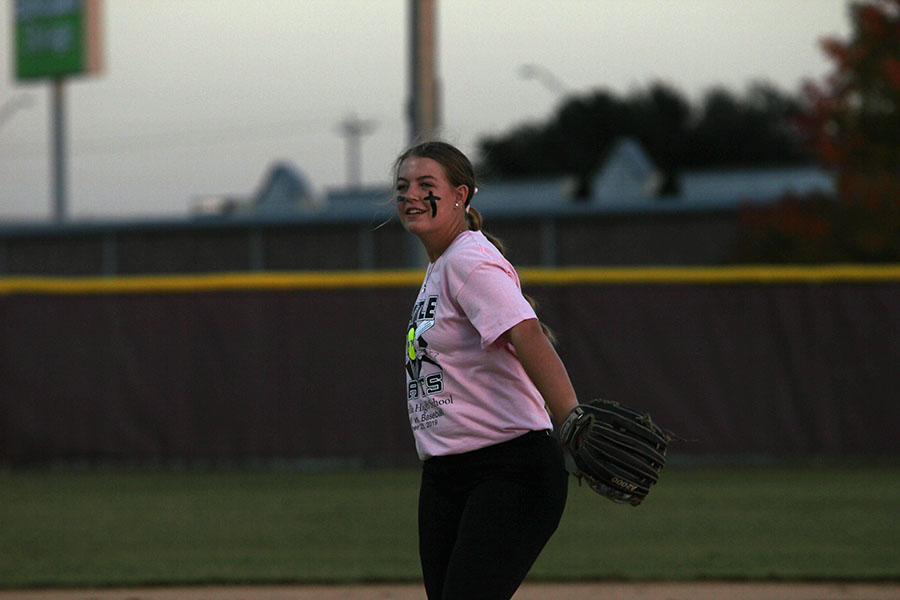Senior softball captain Allie Barentine tosses the ball to another player while warming up for the Battle of the Bats rivalry game on Wednesday, Oct. 23.