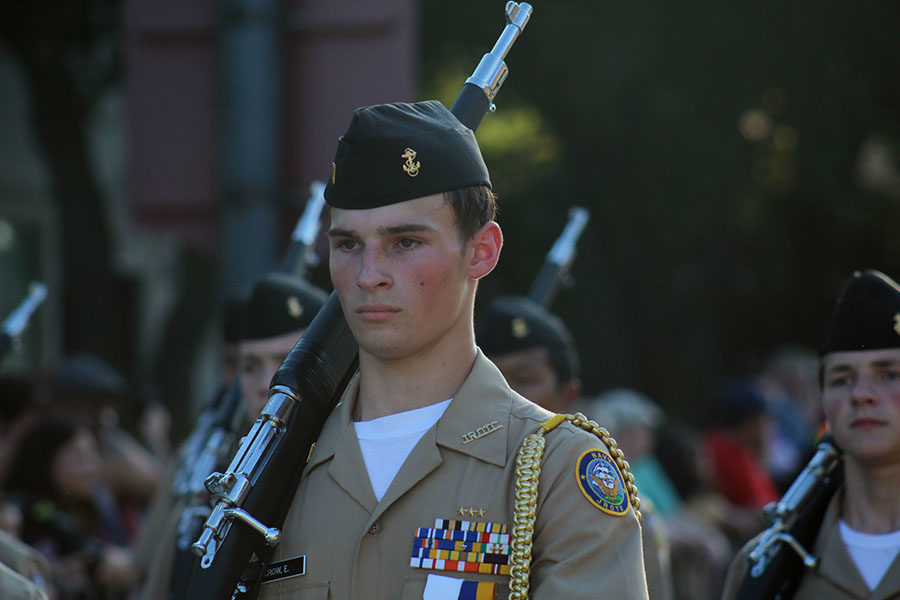 Senior Ethan Crow walks along the homecoming parade route with the NJROTC on Wednesday, Oct. 2.