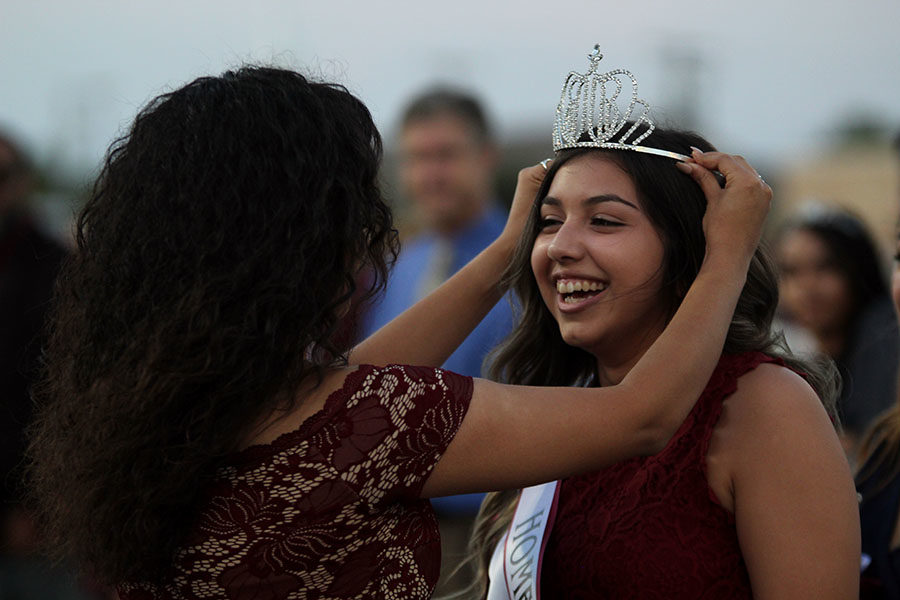 Alumna Ariana Mata crowns senior Kayla Rios as homecoming queen.
