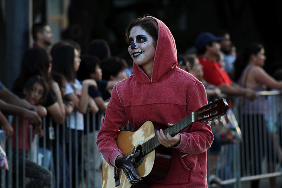 Junior Sofia Sandoval, dressed as Miguel from Coco, plays guitar in front of the girls soccer teams float.