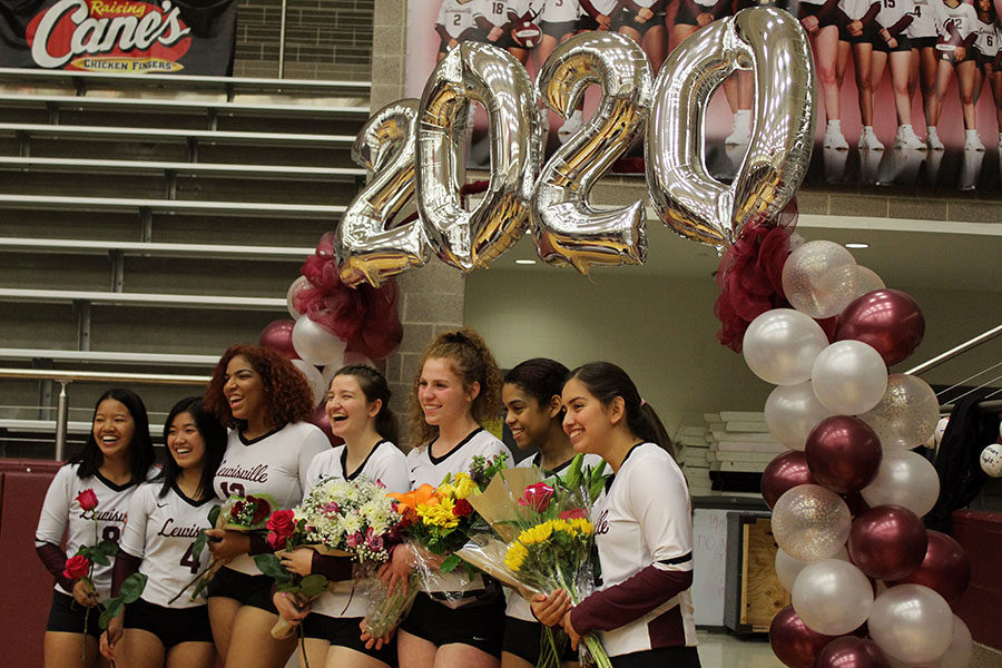 The varsity volleyball seniors pose together under a 2020 archway after being announced at the senior night game on Friday, Oct. 25.
