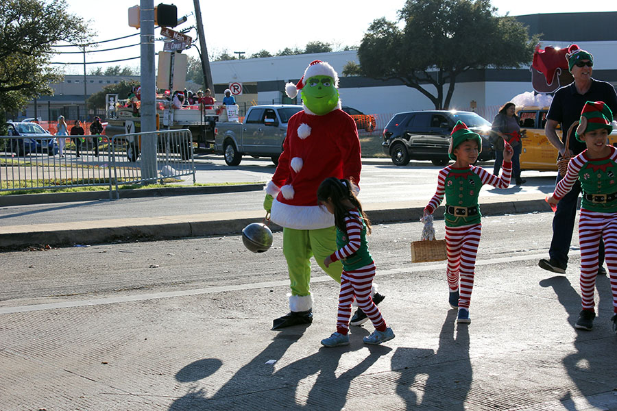 Dr. Seuss character The Grinch walks with kids.