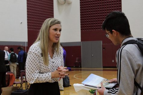 A Texas Tech representative discusses a flyer of information with a student.