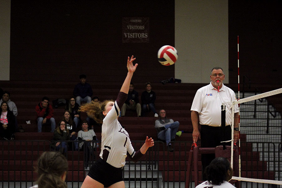 Senior Emerson Coburn spikes the ball over the net at the home game against Irving Nimitz on Friday, Oct. 25.