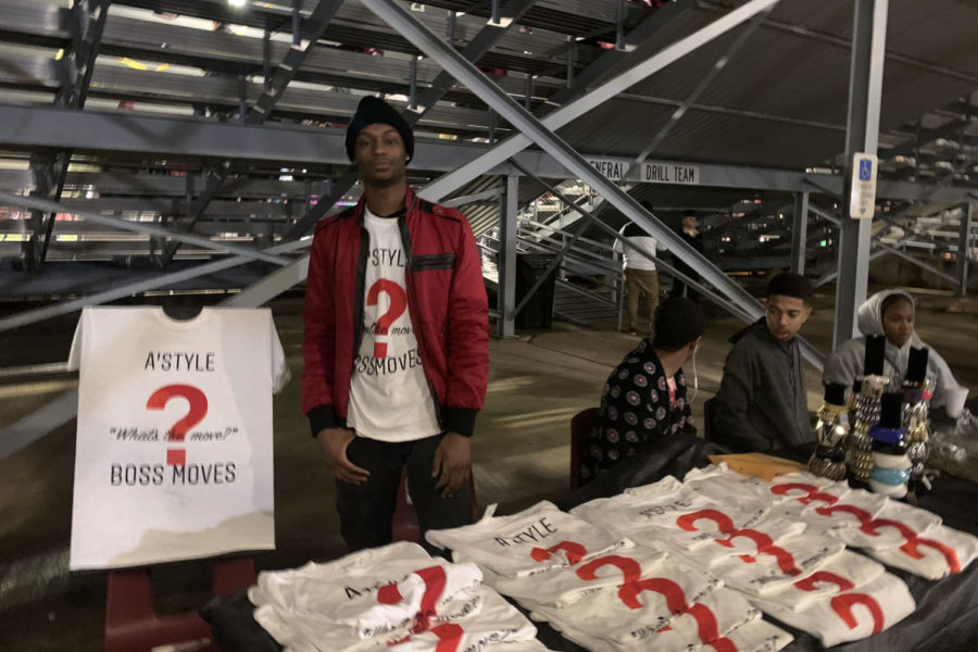 Senior Atrion Sorells poses for a picture as he sells his T-shirts from his clothing line AStyle Productions during the home game against Irving Nimitz on Friday, Oct. 25. Courtesy of Valerie Cooper.