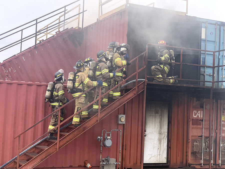 Senior Will Sparks firefighting crew practices saving lives in a burning building.