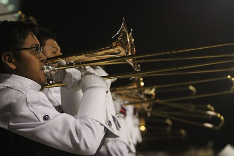 Trombone players cheer on the football team from the bleachers during the homecoming game on Friday, Oct. 22.