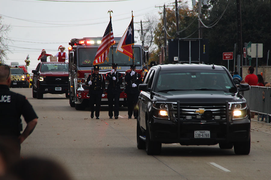 The Christmas Parade in Old Town Lewisville was lead by a police car and four policemen carrying riffles and and the U.S. and Texas flag.