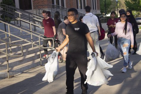 Senior David Mang and other cadets carry the filled trash bags to the dumpster after the clean-up.