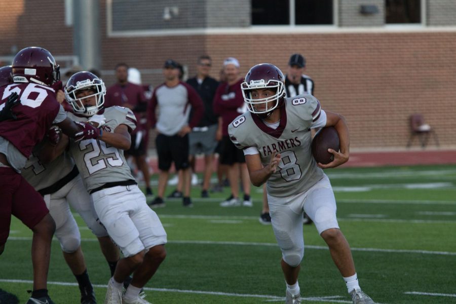 The JV quarterback runs the ball down the field in the spring ball scrimmage game. The offense team and the defense team battled on May 18.
