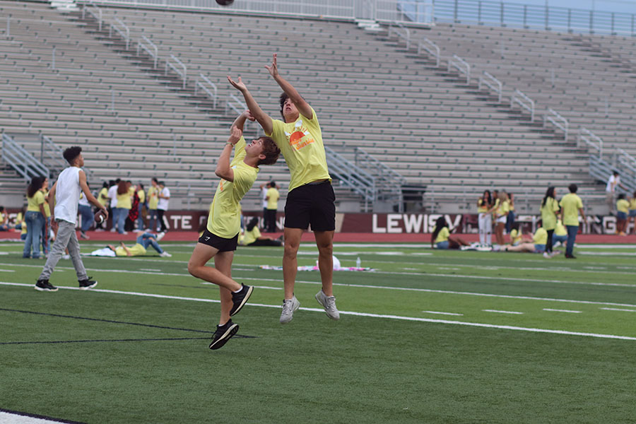 Joshua McCulley and Logan Sadler leap to reach the football. 
