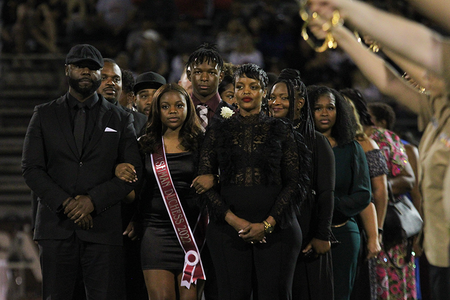 Homecoming court nominees wait alongside their guardians to be announced and walked across the football field.