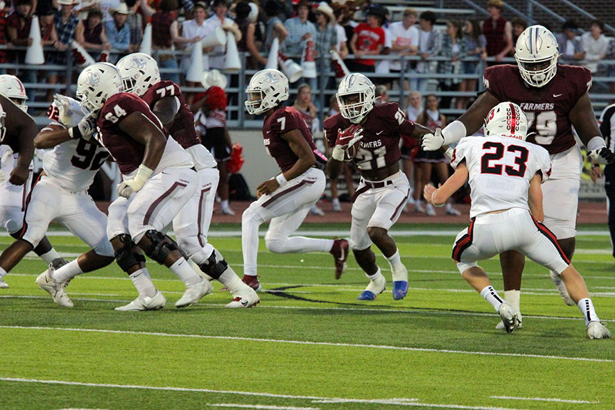 Running back Viron Ellison (21) speeds through the middle of line backers Sean Hutton (64) and Quaveon Davis (79) who protect against Coppell defense.