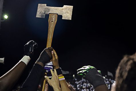 Football players gather around the axe and lift it up after they win BOTA with a final score of 17-14.