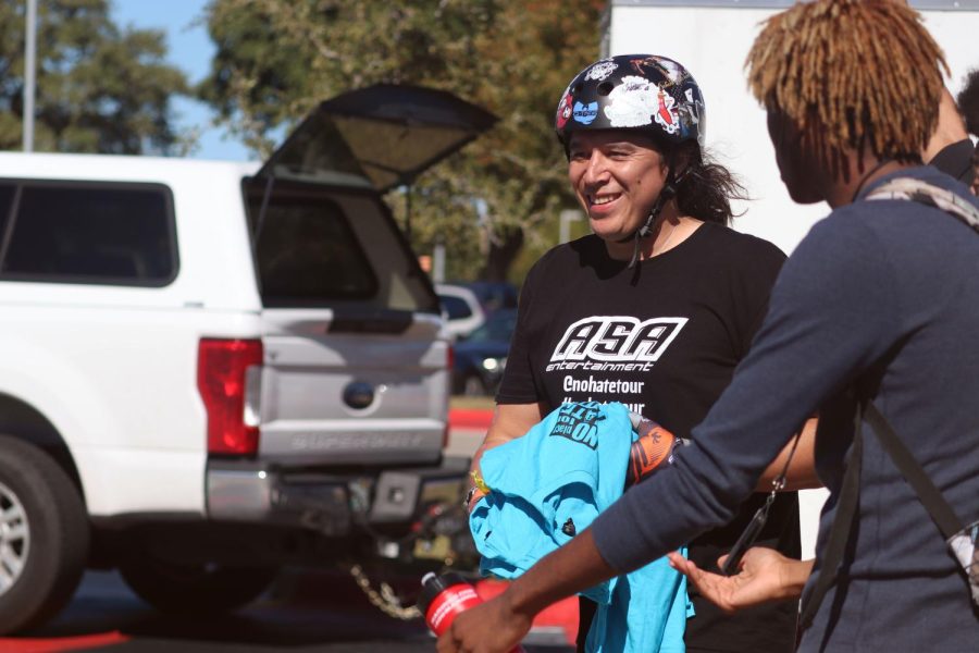 BMX biker Koji Kraft hands out T-shirts to students.