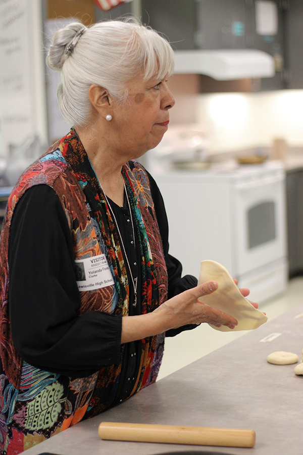 Former LISD teacher Yolanda Flores mentors students on the techniques of making a tortilla. She showed the process of flattening a tortilla then aided students through the cooking.