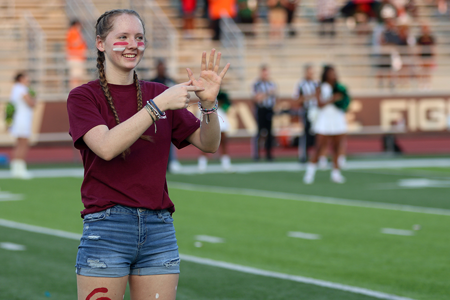 Senior Amie AJ Jackson signs the national anthem at the Maroon Out home game against Naaman Forest. 