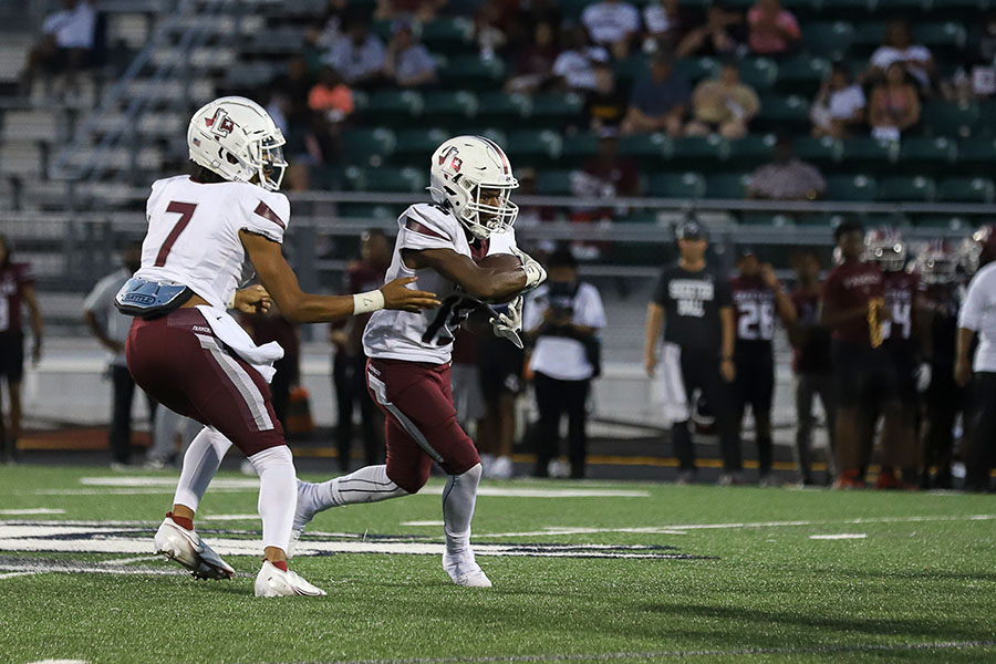 Running Back Addison Wells (15) snatches the ball from quarter back Ethan Terrell (7) in the third game of the regular session against Mesquite. 