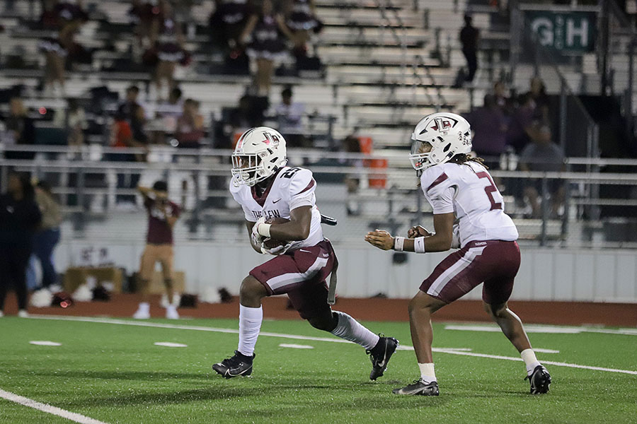 Running back Lyedward Williams (25) snatches the ball from quaterback Zephen Walker (2) in the fourth quarter of the Mesquite game.