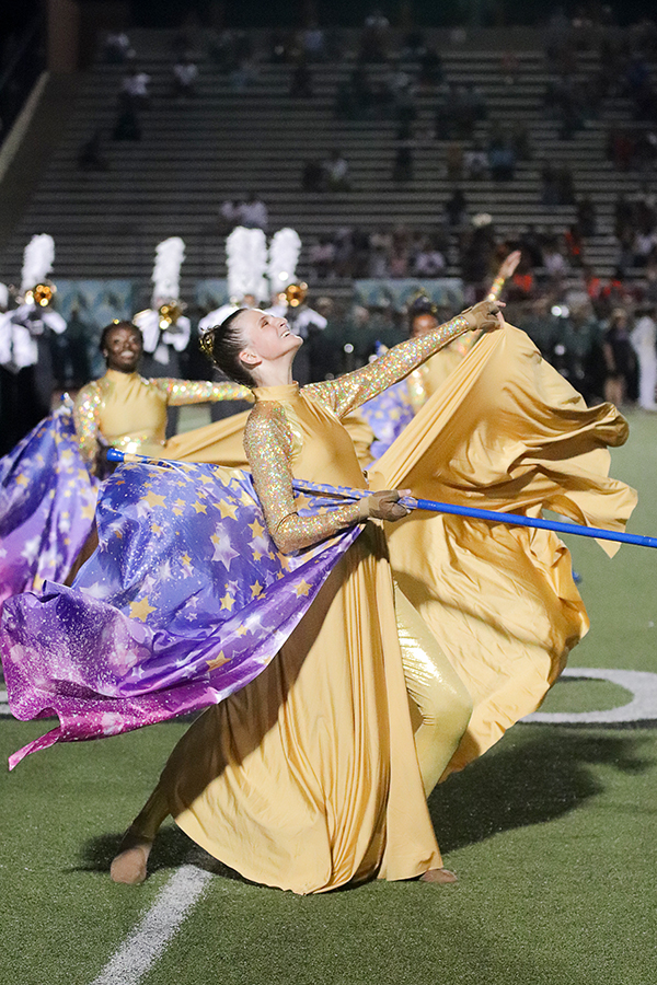 Color guard member Jayden Gienau performs the Constellations competition routine during halftime.