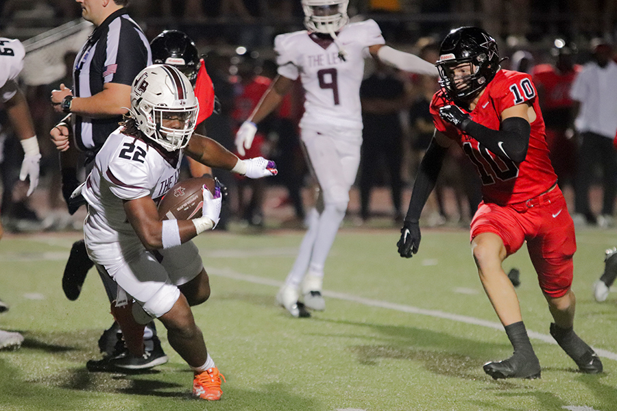 Running back Vance Walker runs the ball downfield against Coppell safety Alex Kraus in the game on Sept. 29.