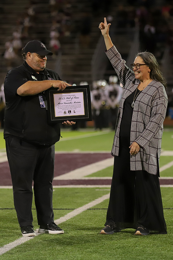 Principal Jim Baker holds the certificate of newly inducted Samantha Montano as she earns a spot in the Lewisville Hall of Fame.