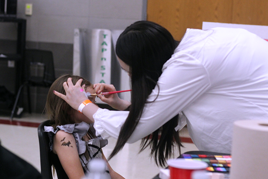 Senior Alexia Huynh helps face paint for the National English Honor Society booth. 