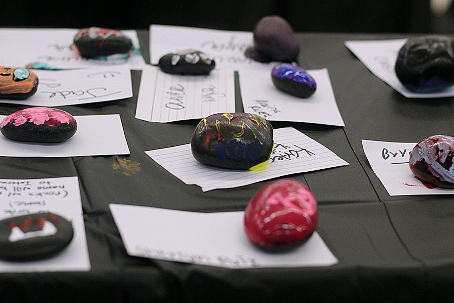 Painted rocks sit on the table to dry at Interacts rock painting booth.